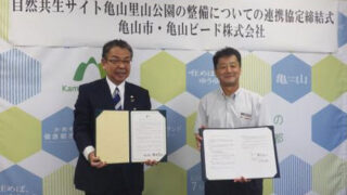 協定式に出席した亀山市の櫻井義之市長（左）と亀山ビードの今村洋文社長（右）